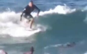 Surfer Encourages Younger Surfer To Take The Wave