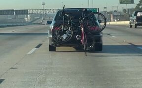 Bicycle Rides Behind Car on Highway