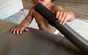 Baby Playing with Vacuum Puts Hose to Face