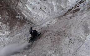 Hill Climber Trying to Stop Tumbling Snowmobile